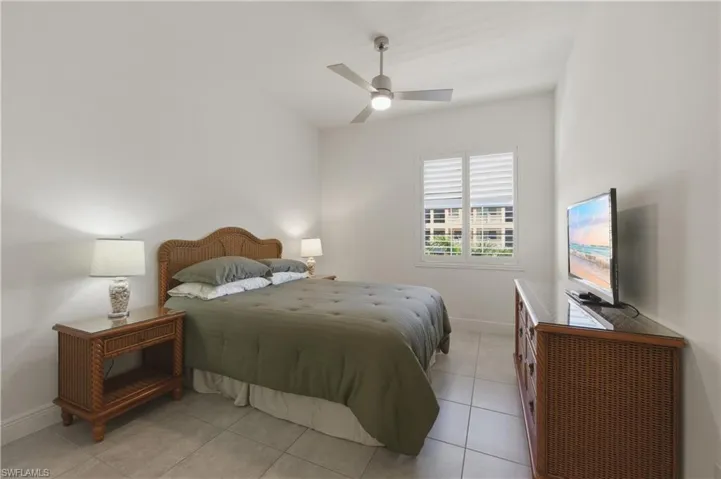 Bedroom with ceiling fan and light tile patterned floors