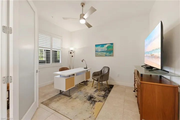 Office with light tile patterned flooring and a ceiling fan