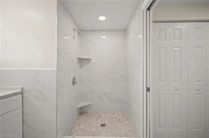 Bathroom featuring a closet, a stall shower, and vanity