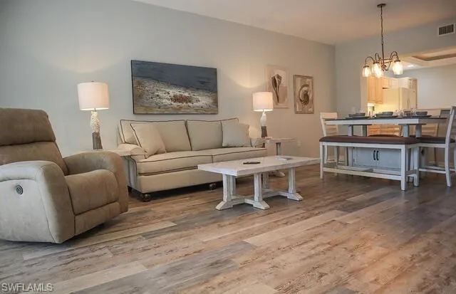 Living area featuring light wood-type flooring and a chandelier