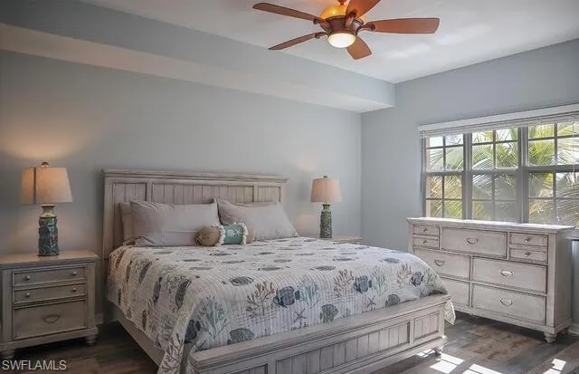 Bedroom with dark wood-style floors, access to exterior, and a ceiling fan