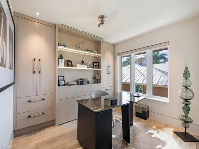 Third bedroom, laid out as an office. There is a Zoom Bed concealed behind the shelving and full depth closets on either side.