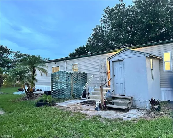 Back of house with entry steps and a yard