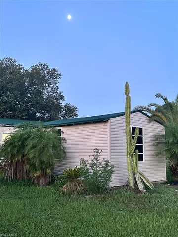View of property exterior featuring a lawn