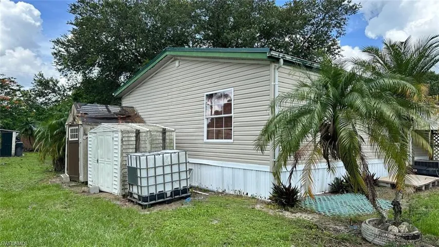 View of home's exterior with a storage unit and a lawn