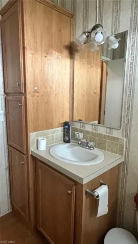 Bathroom with vanity, backsplash, and wood finished floors