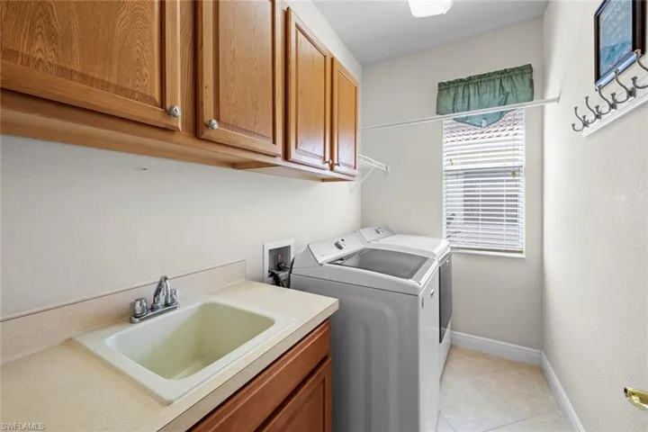 Laundry with sink and upper and lower cabinets