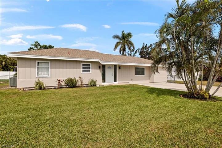 Ranch-style house featuring central AC unit, a front yard, and fence