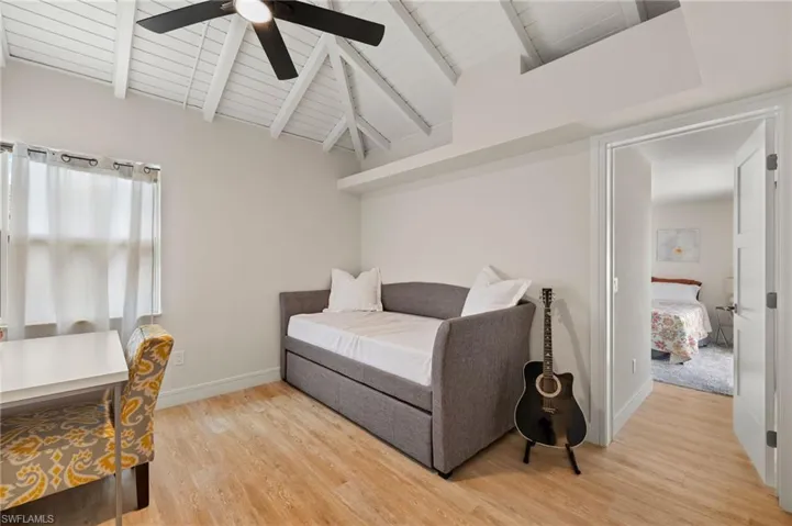 Office/Bedroom featuring lofted ceiling with beams, wooden ceiling, a ceiling fan, baseboards, and light wood finished floors