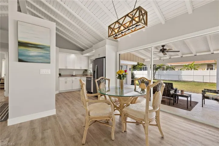 Dining room featuring beam ceiling, baseboards, and light wood finished floors