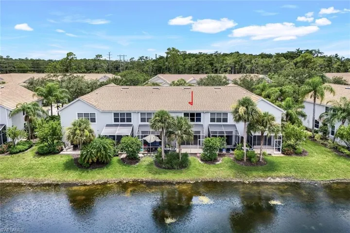 Rear view of property with a water view and a lawn