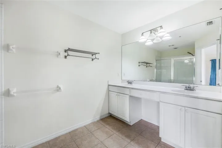 Bathroom featuring tile patterned floors and double vanity