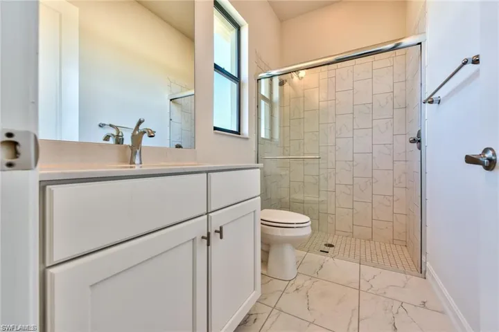 Full bath with vanity, toilet, and a shower stall