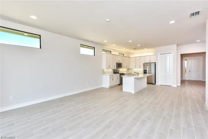 Kitchen with visible vents, tasteful backsplash, open floor plan, stainless steel appliances, and light countertops