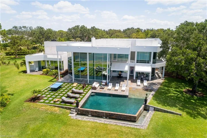 Rear view of house featuring a yard, a patio, and a balcony