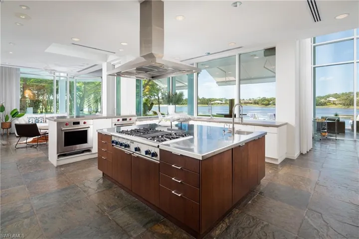 Kitchen featuring island exhaust hood, plenty of natural light, appliances with stainless steel finishes, and sink