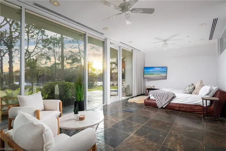 Bedroom featuring ceiling fan, floor to ceiling windows, and access to outside