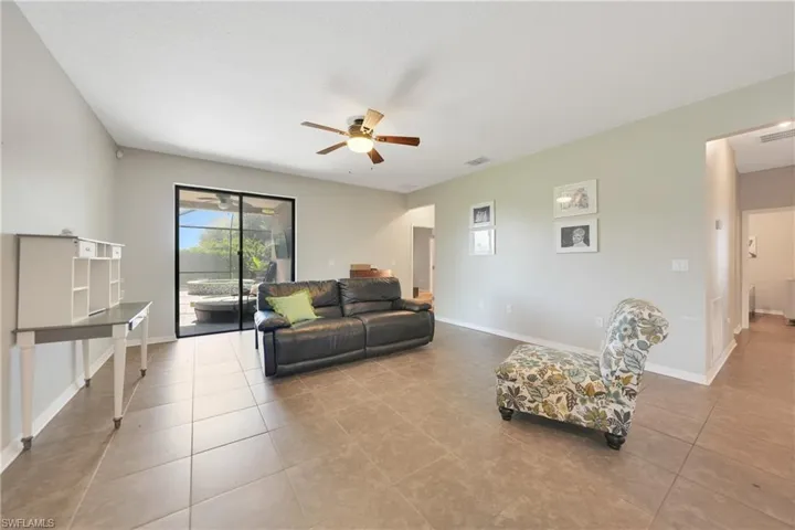 Living room featuring a ceiling fan, tile patterned floors, baseboards, and visible vents