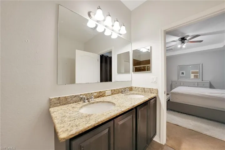 Ensuite bathroom with a ceiling fan, double vanity, a sink, and ensuite bathroom