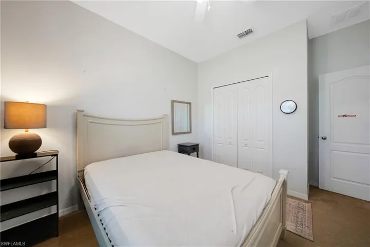 Carpeted bedroom with a closet, baseboards, and visible vents