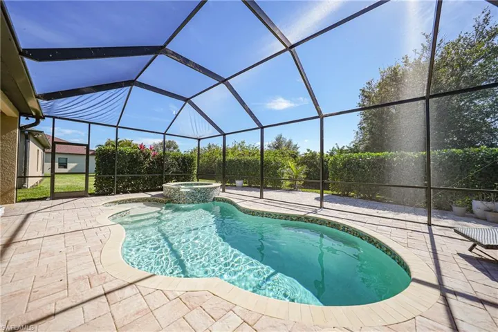 View of pool featuring a pool with connected hot tub, a lanai, and a patio