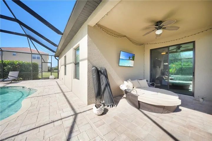 View of patio featuring a ceiling fan, an outdoor pool, and a lanai