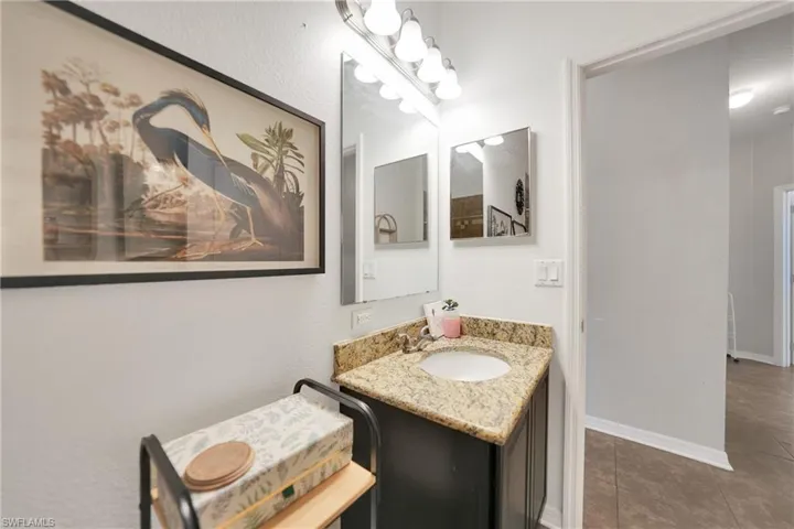 Bathroom with baseboards, tile patterned flooring, and vanity