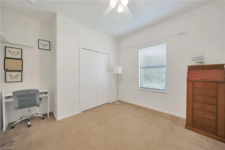 Office space featuring light carpet, baseboards, and ceiling fan