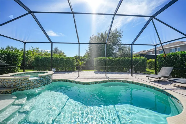 View of swimming pool featuring a pool with connected hot tub, a lanai, and a patio