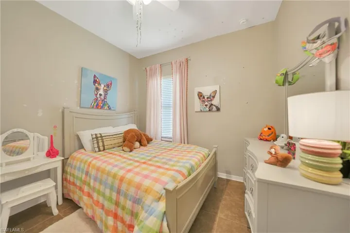 Bedroom featuring tile patterned floors, ceiling fan, and baseboards