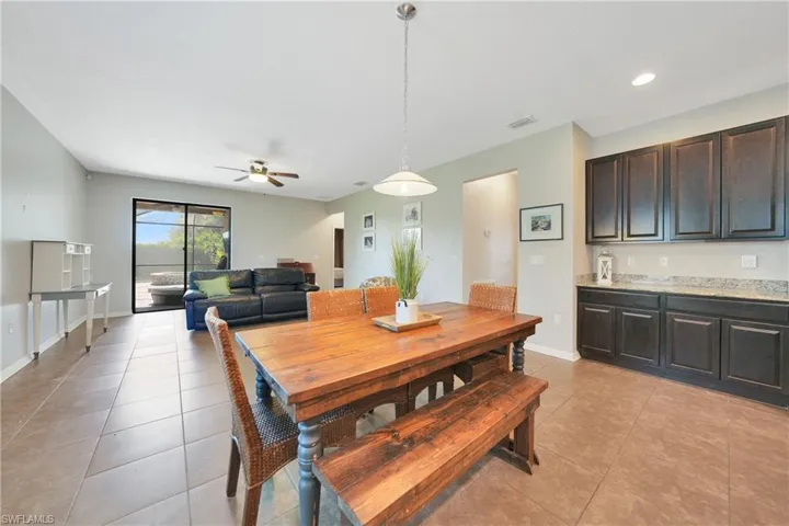 Dining space featuring light tile patterned floors, visible vents, baseboards, and a ceiling fan