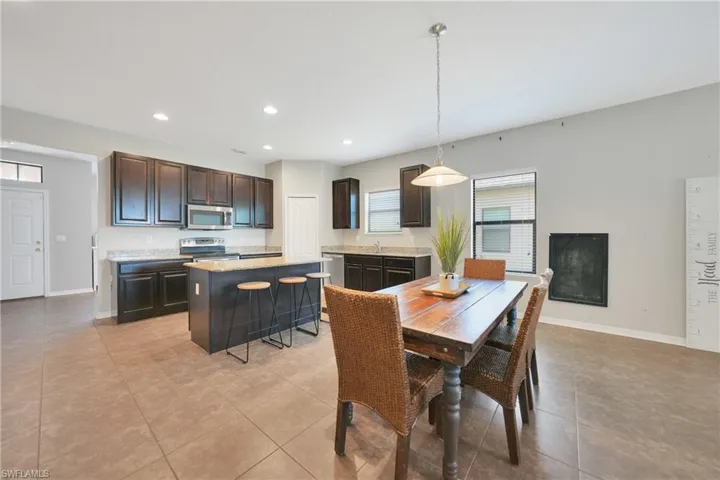 Dining space with light tile patterned flooring, baseboards, and recessed lighting
