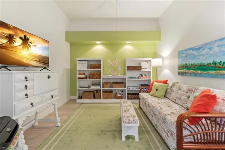 Living room with a towering ceiling and hardwood / wood-style flooring