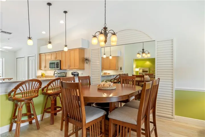 Dining space featuring a chandelier, light hardwood / wood-style flooring, lofted ceiling, and sink