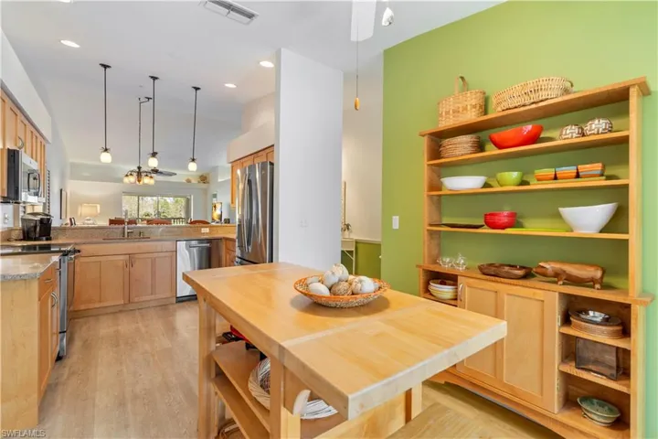 Kitchen featuring sink, stainless steel appliances, kitchen peninsula, pendant lighting, and light brown cabinetry