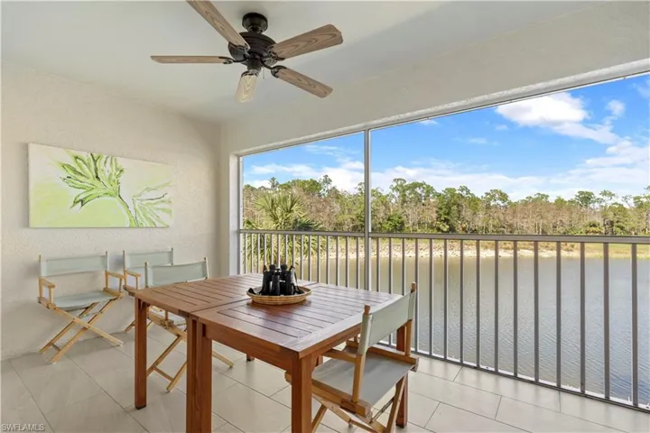 Sunroom / solarium featuring ceiling fan and a water view