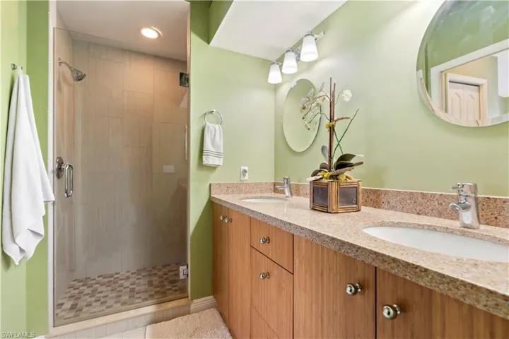 Bathroom with vanity, tile patterned floors, and a shower with shower door