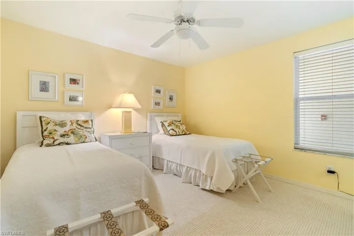 Bedroom with ceiling fan and light carpet