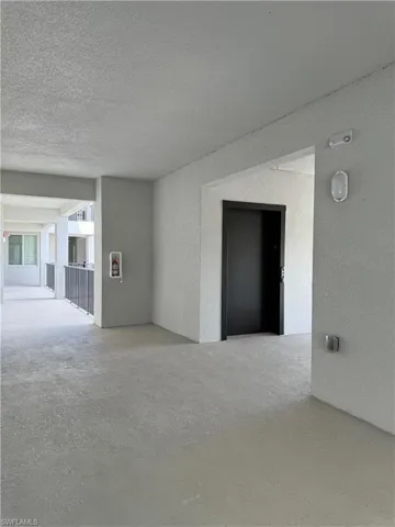 Empty room featuring a textured ceiling and elevator