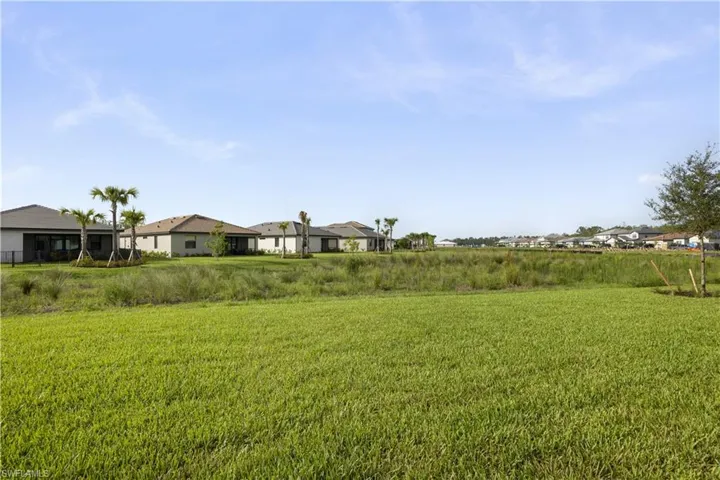 Expansive green lawn bordering a natural wetland area