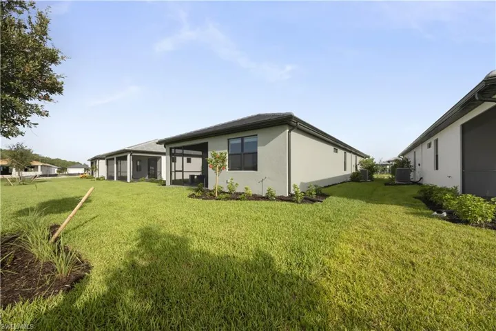 Expansive green lawn bordering the rear of the property