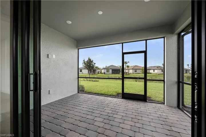Screened-in patio featuring multi-tone paver flooring and recessed lighting