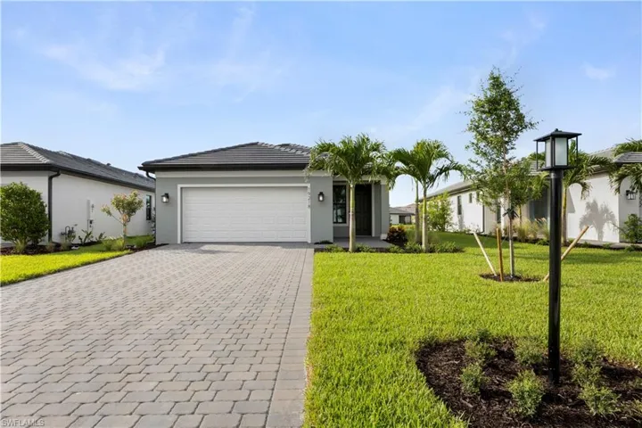 Single-story residence featuring a gray exterior, dark roof, and a white garage door