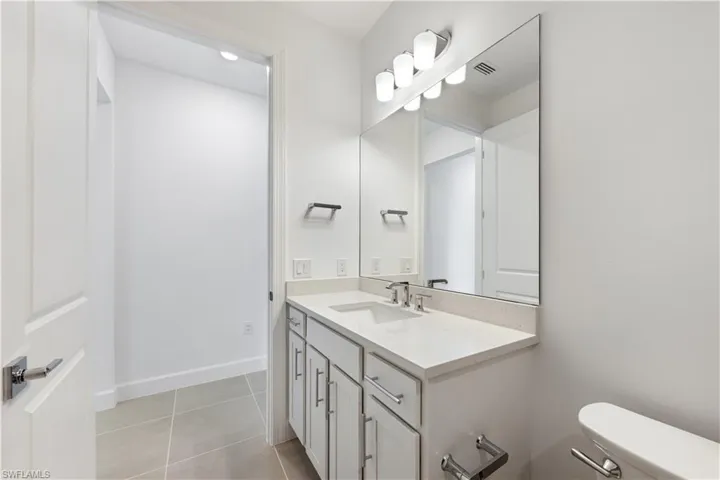Bathroom vanity featuring a rectangular undermount sink, a light-toned countertop, and chrome fixtures