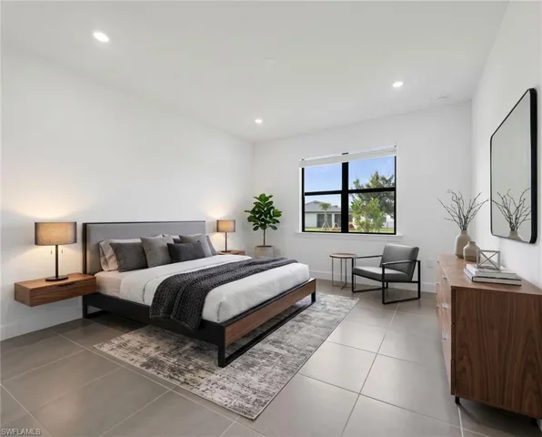 *Virtually Staged*Spacious room featuring large format tile flooring, recessed lighting, and a large window with roller shades