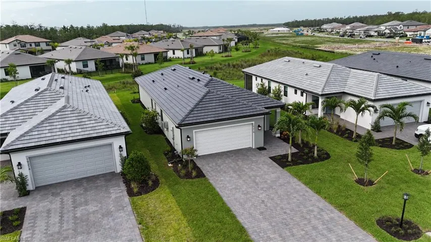 Contemporary single-story residence with a gray tile roof and a paver driveway