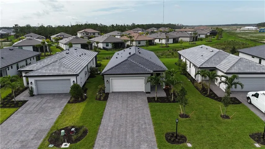 Contemporary single-story home featuring a tile roof and light-toned exterior