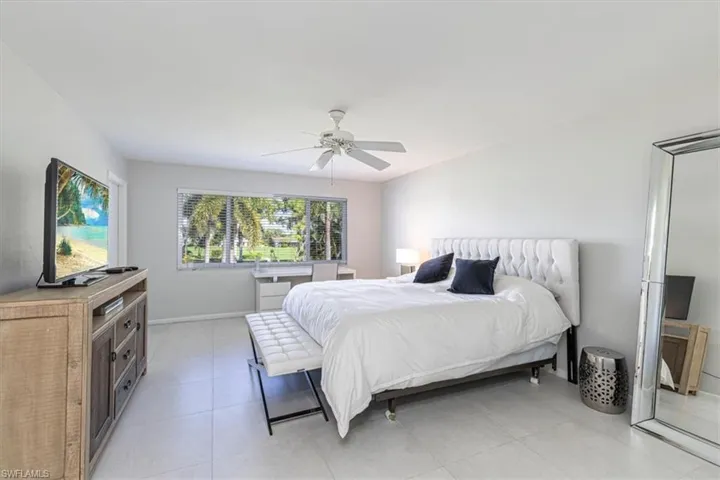 Bedroom with ceiling fan and light tile patterned floors