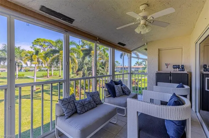 Sunroom / solarium with a ceiling fan, an outdoor living space, and a balcony