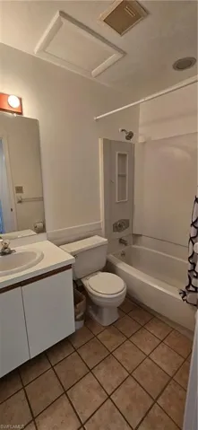 Bathroom featuring shower / bath combo, vanity, and light tile patterned floors